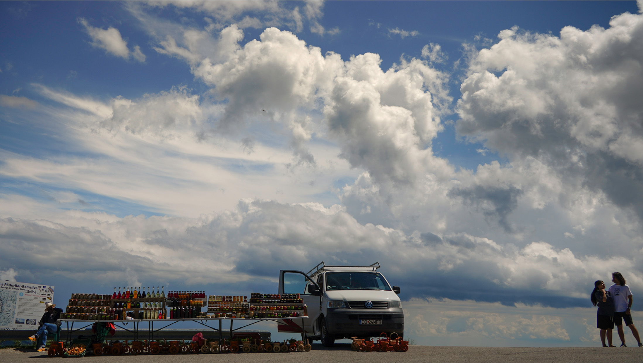 Roadside market beneath a dramatic cloud-filled sky