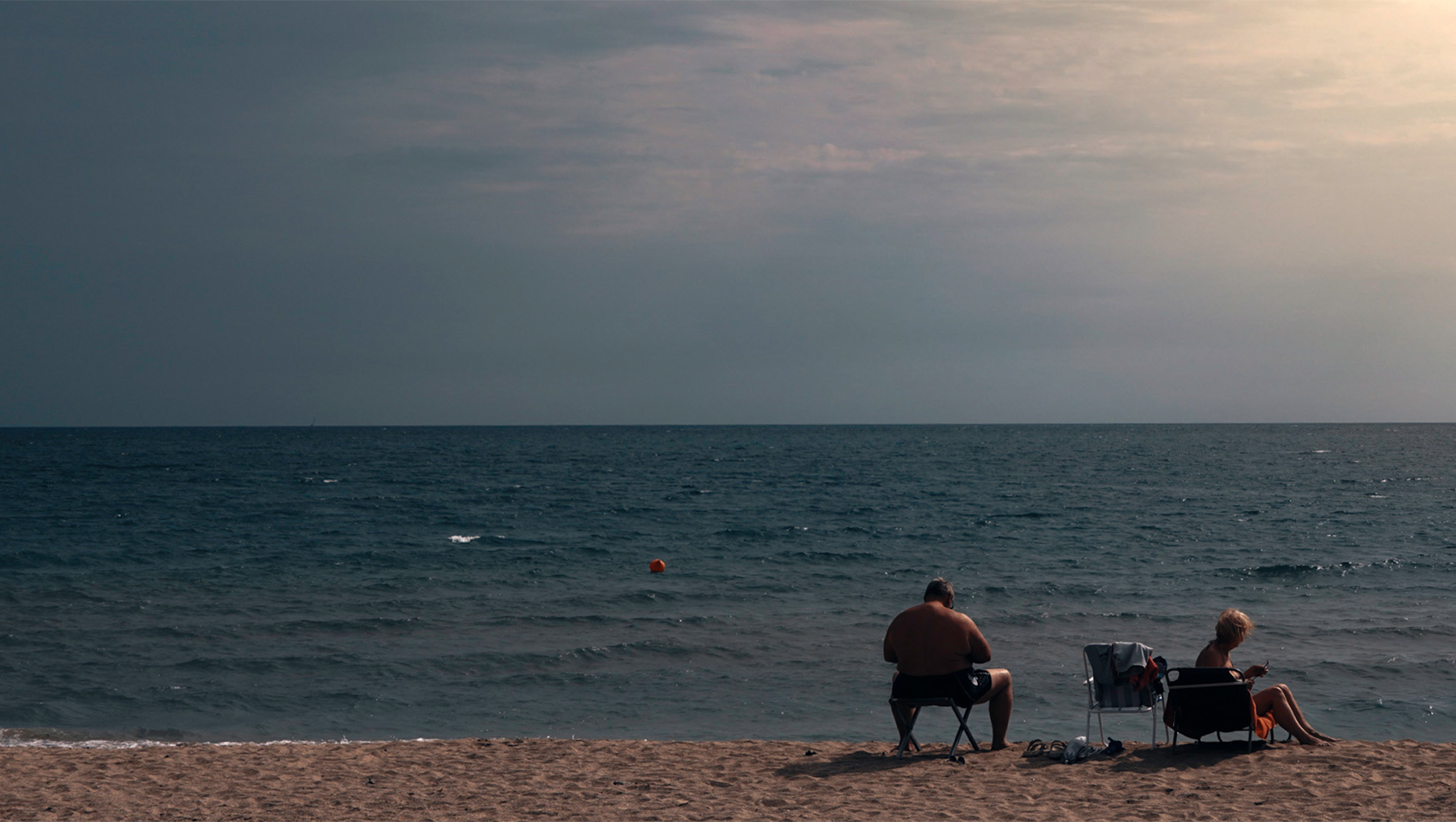 Two people seated at the edge of the Black Sea