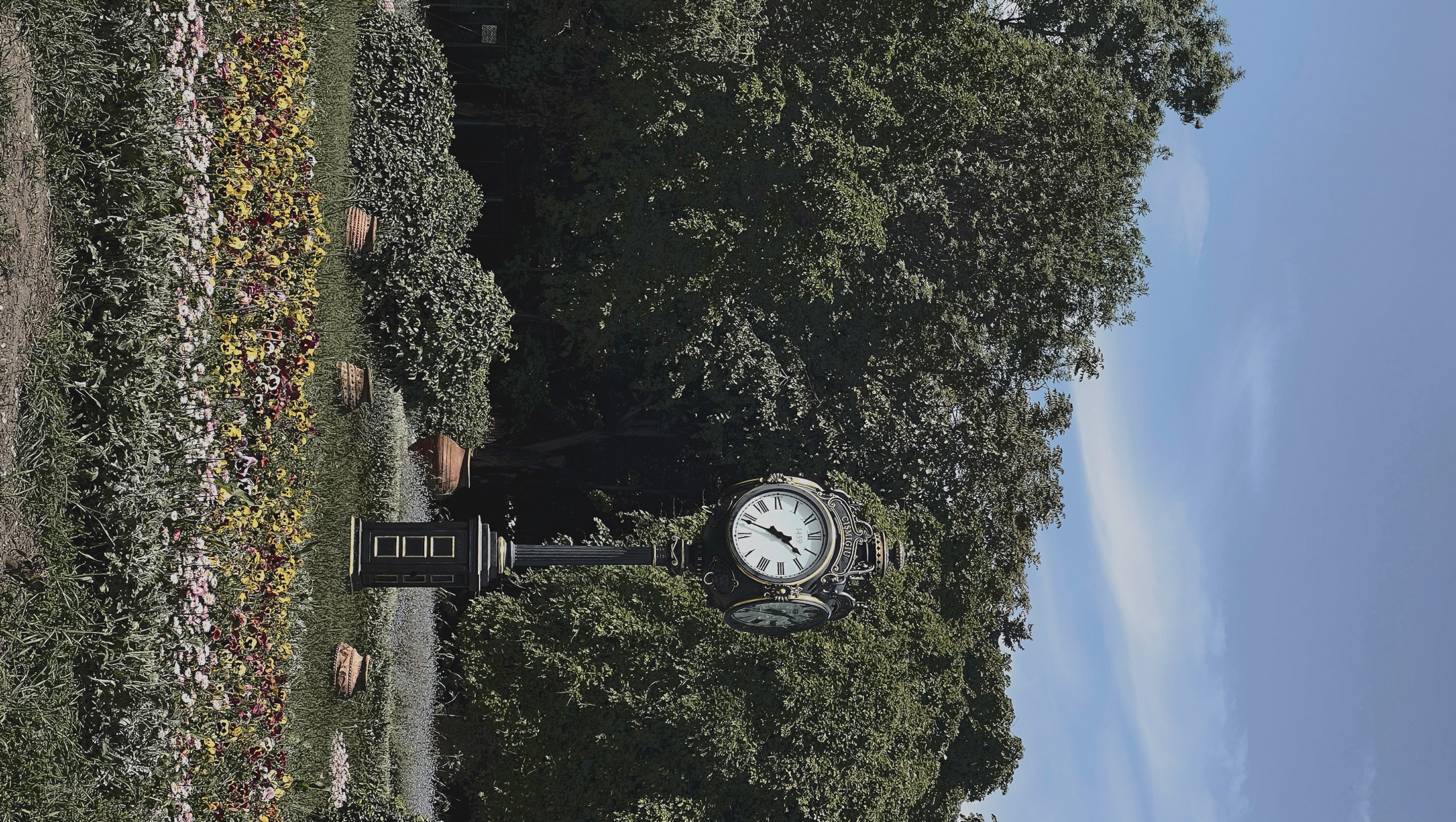 Ornamental park clock surrounded by flowers