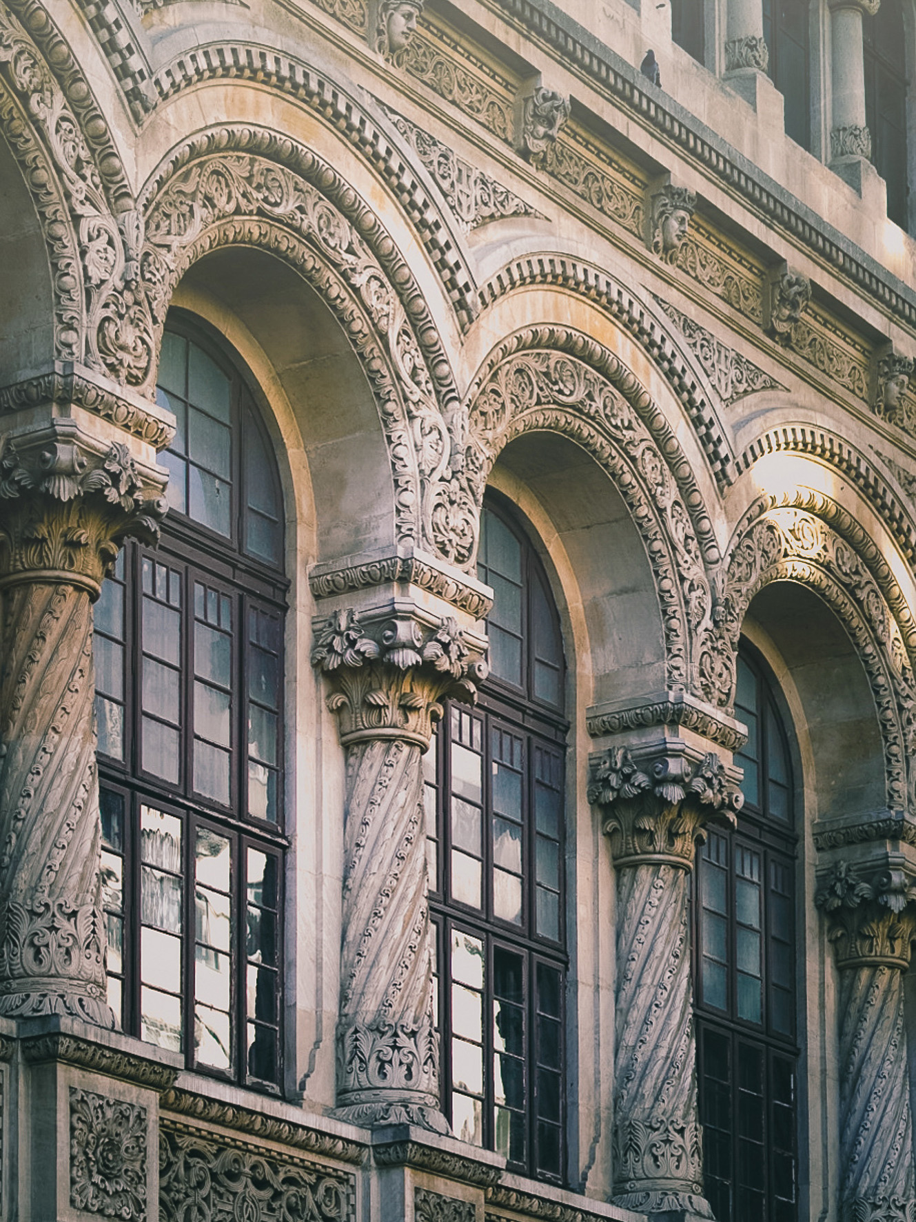 Ornate arched windows on a historic Bucharest facade