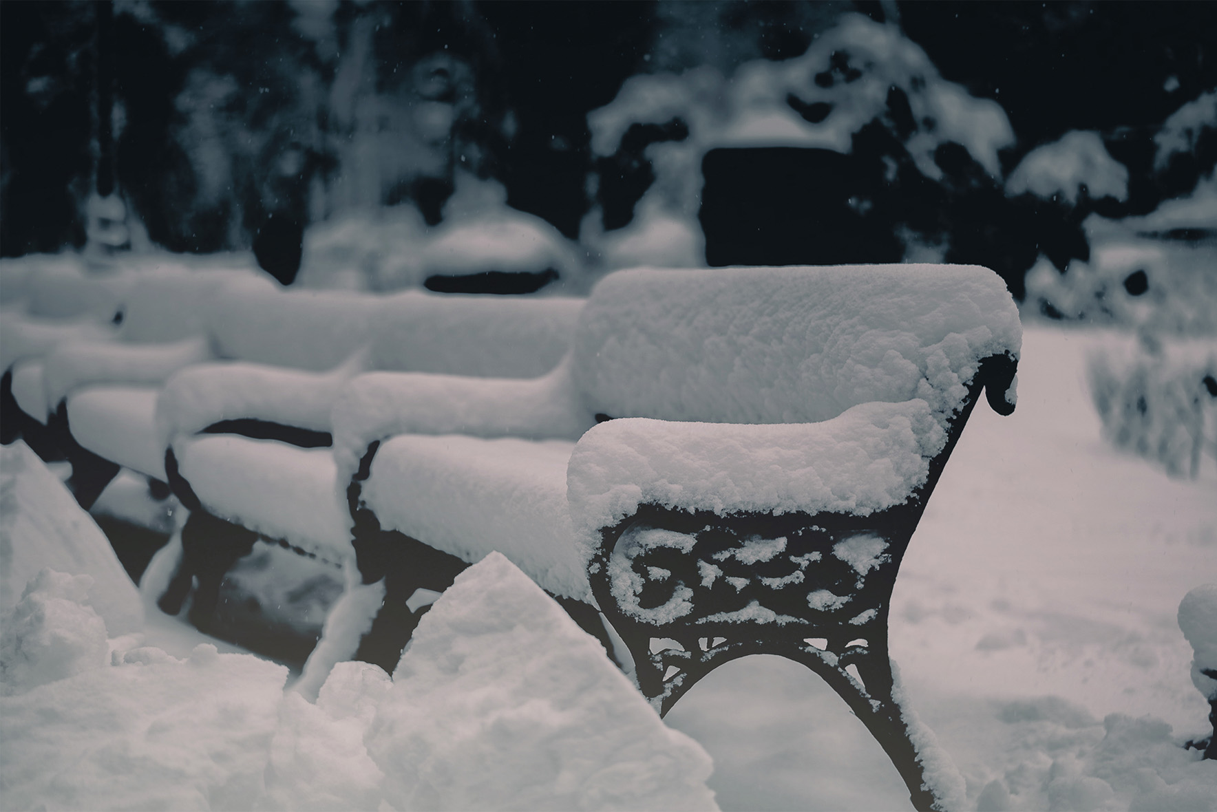 Ornate park bench covered in fresh snow